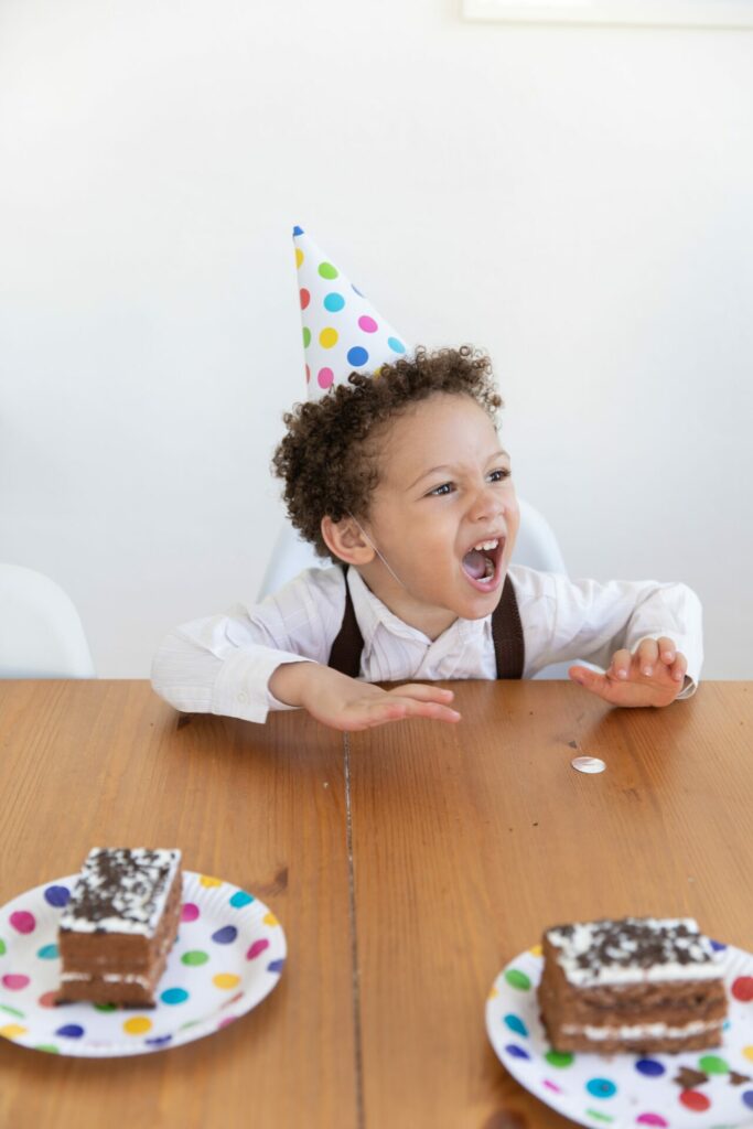 a little boy screaming at a birthday party