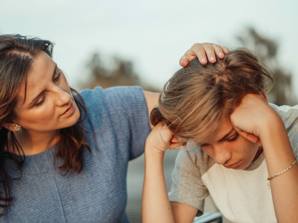 a mom comforts her son